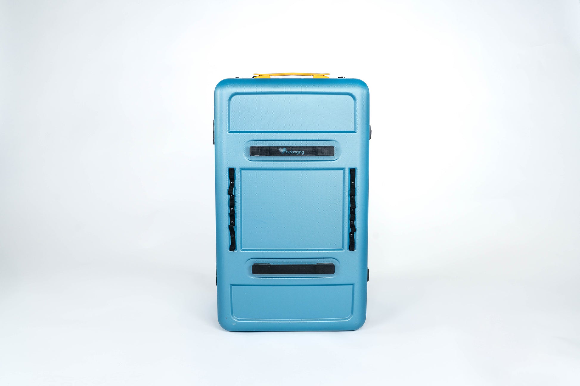 Front view of the closed blue Belonging LifeLocker Founders Bundle showing molded exterior panels, front handle, and black attachment straps on a white studio background.