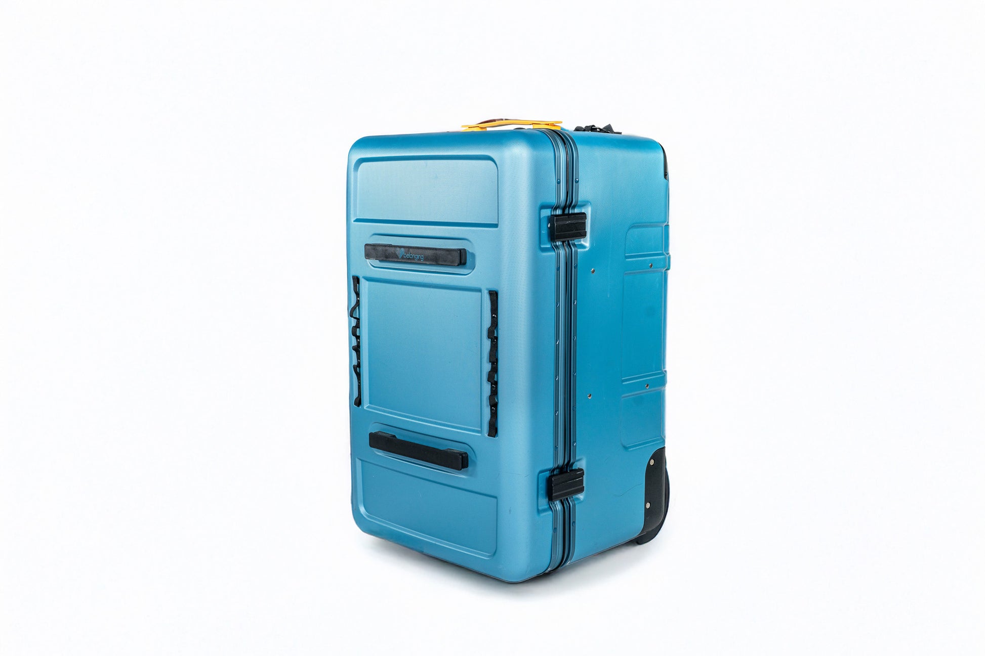 Corner view of the closed blue Belonging LifeLocker Founders Bundle showing molded exterior panels, front handle, and black attachment straps on a white studio background.