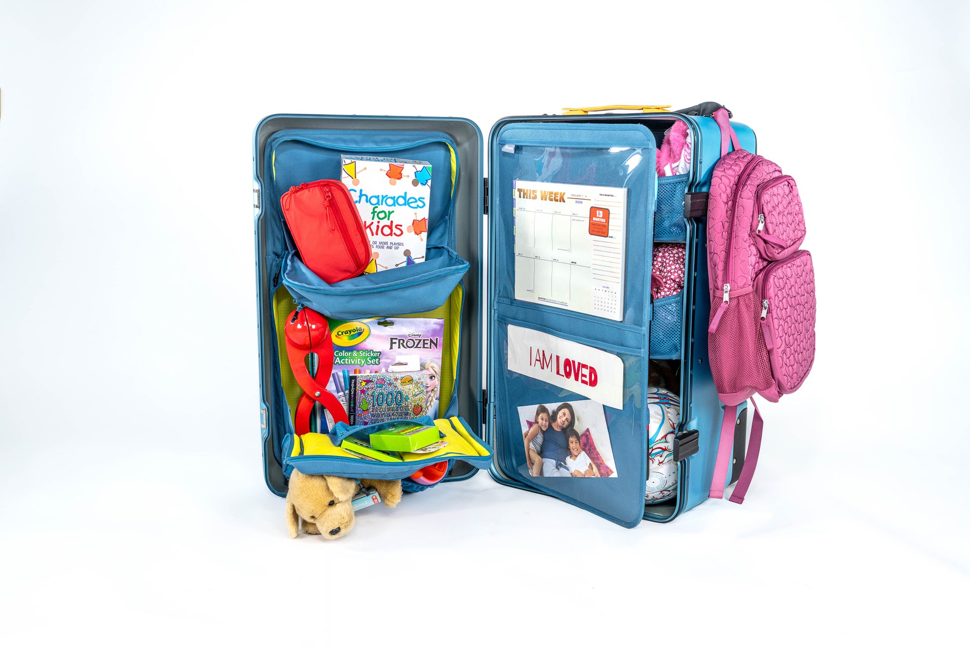 Open blue Belonging LifeLocker Founders Bundle fully packed with books, activity sets, stuffed animal, calendar, photo insert, and a pink backpack attached to the side, displayed on a white studio background.