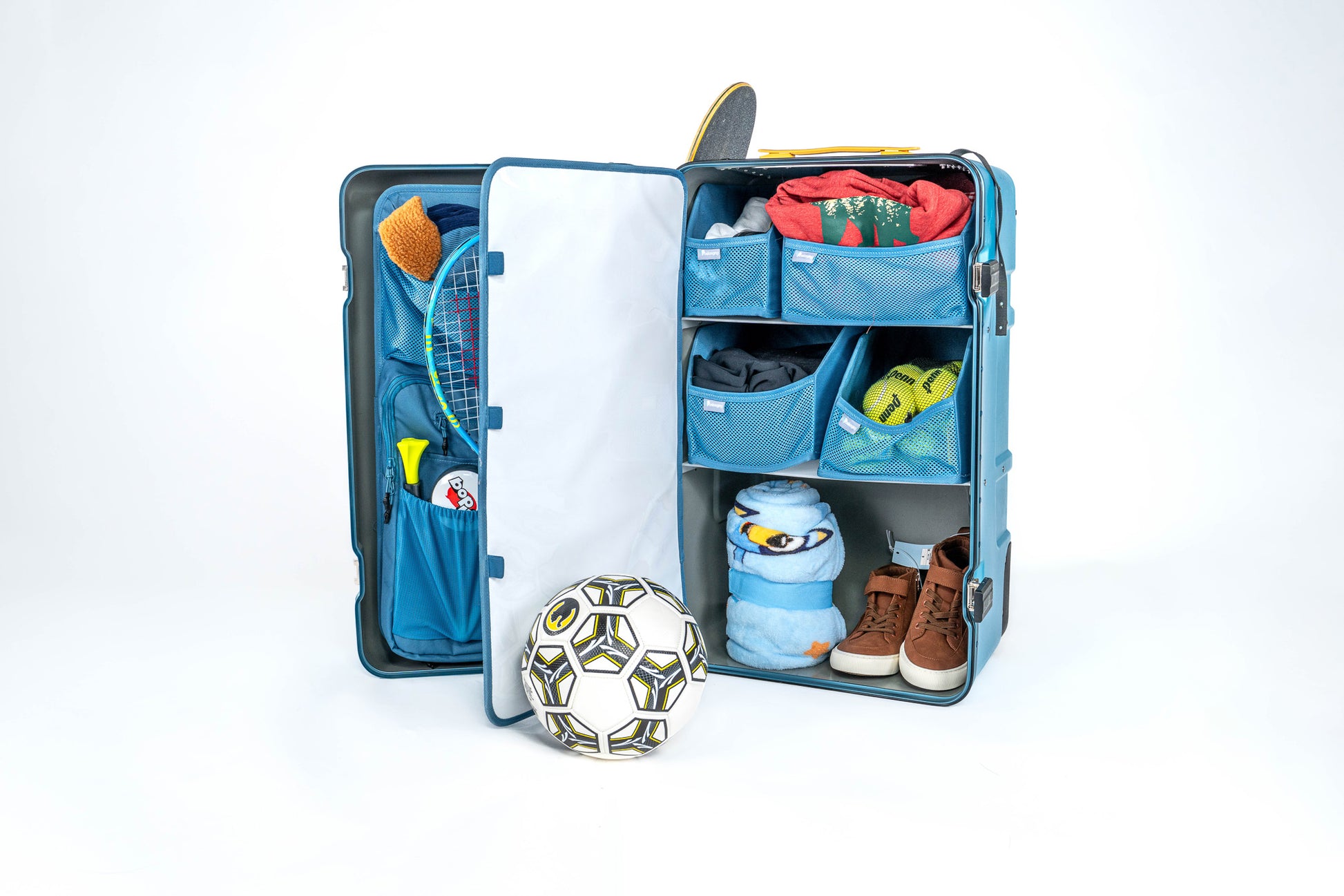 Open blue Belonging LifeLocker Founders Bundle packed with folded clothing, mesh storage compartments, a tennis racket, soccer ball, blanket, and shoes, displayed on a white studio background.